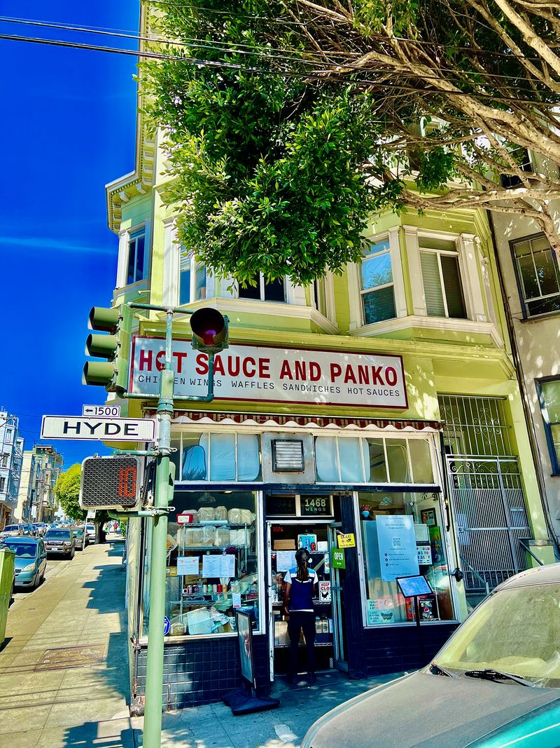 A streetcorner restaurant sign that says 'HOT SAUCE AND PANKO'.