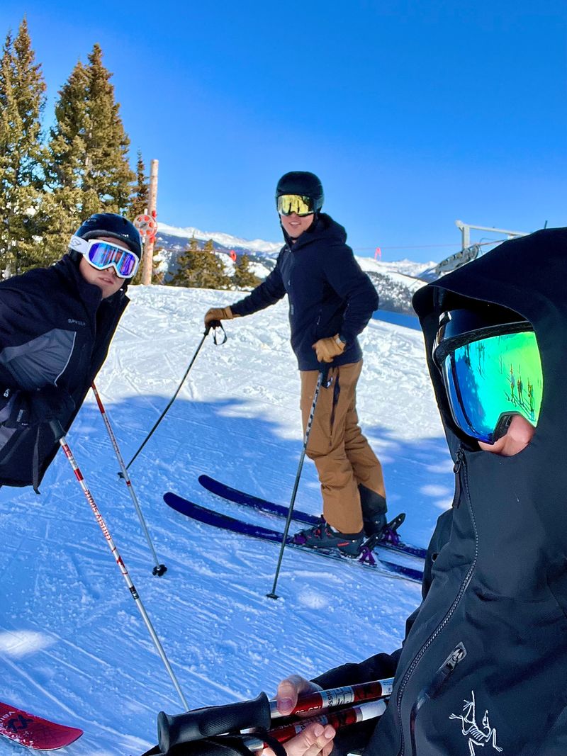 3 friends at the top of a ski run.
