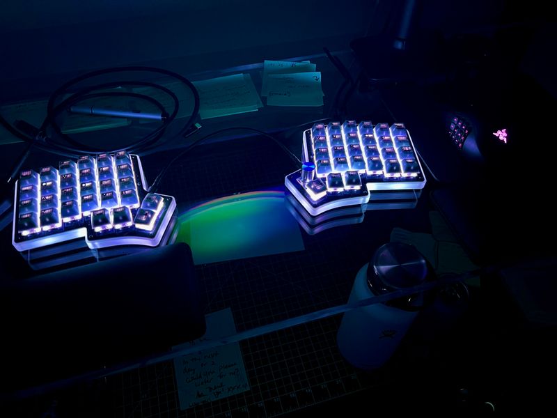An Iris v8 split keyboard illuminated bright white in the dark.